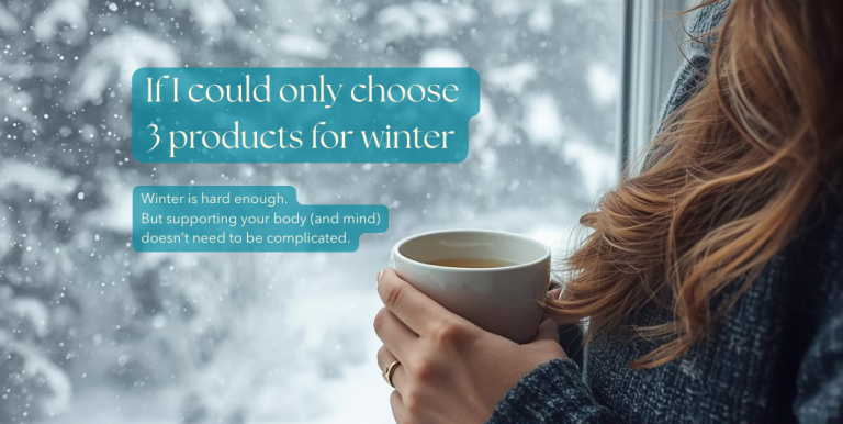 Winter self-care - woman in knit sweater holding tea by window during snowfall, essential winter wellness products